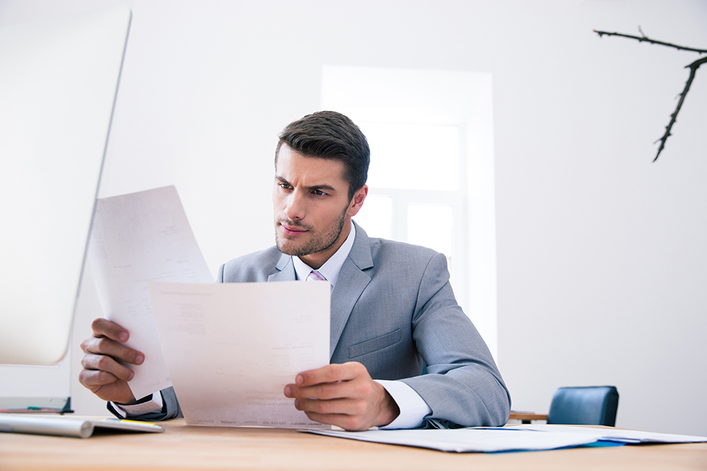 Businessman reading papers in office