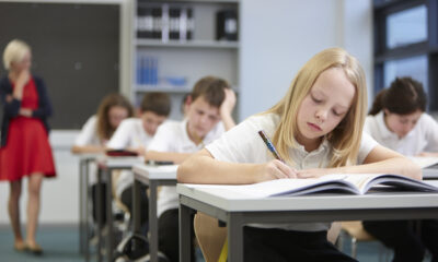 Female teacher watching class doing educational exam