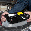 Auto mechanic replacing car battery
