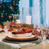 Festive place setting table, next to the Christmas tree