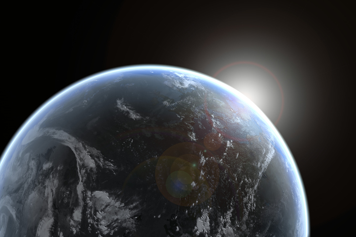 Sun emerging over planet earth