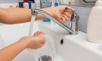 The child opens the faucet in the bathroom, and adjusts the warmth of the water