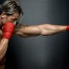 Muscular boxer punching heavy bag