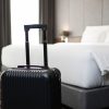 A suitcase placing in front of the bedroom in luxury hotel room