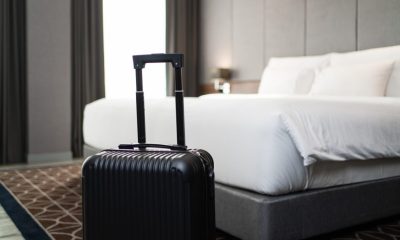A suitcase placing in front of the bedroom in luxury hotel room